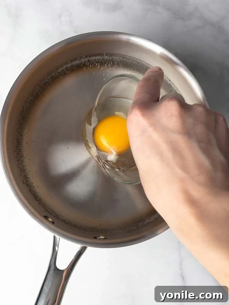 Mastering the Poached Egg 5 An egg being carefully dropped into the center of a swirling pot of hot water, illustrating the beginning of the poaching process.