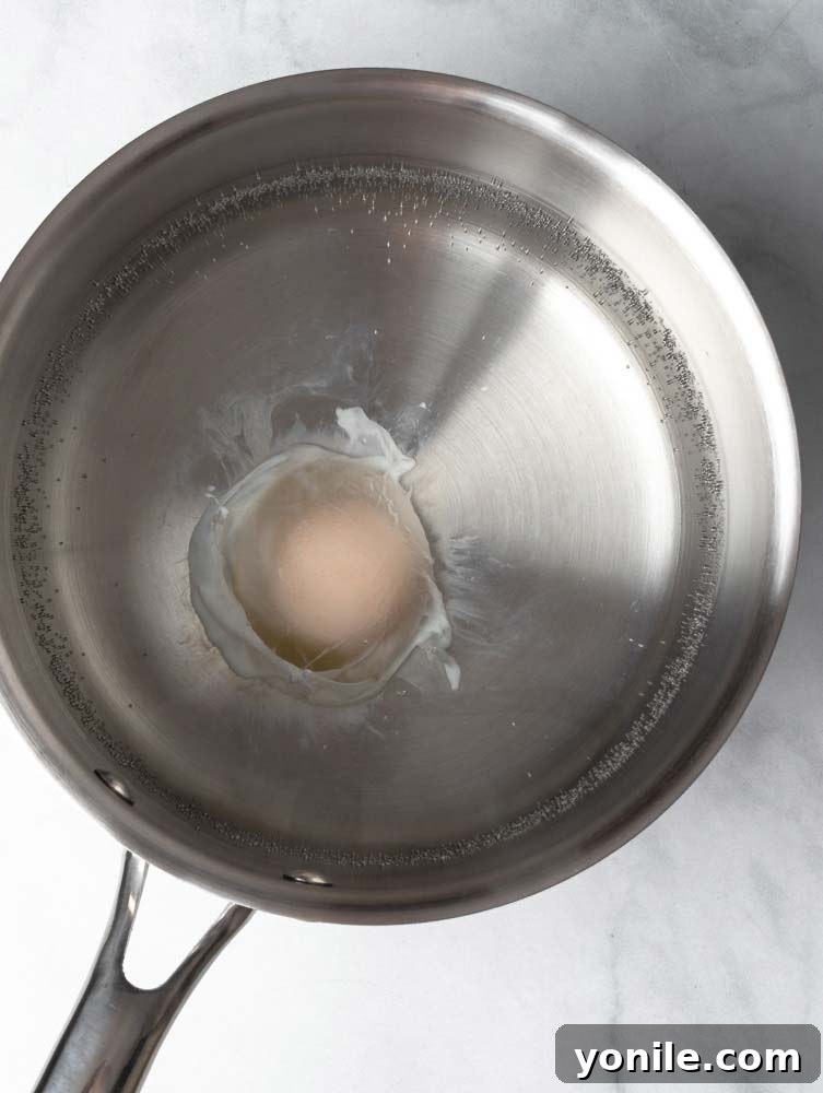 Mastering the Poached Egg 7 A perfectly poached egg gently lifted from a pot of hot water with a slotted spoon, ready to be served.