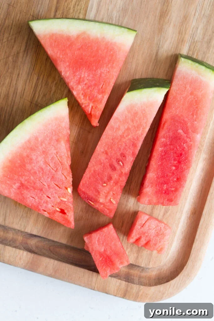 Slice Watermelon Like a Pro 2 Beautifully cut watermelon wedges, sticks, and cubes arranged on a platter, ready for serving.