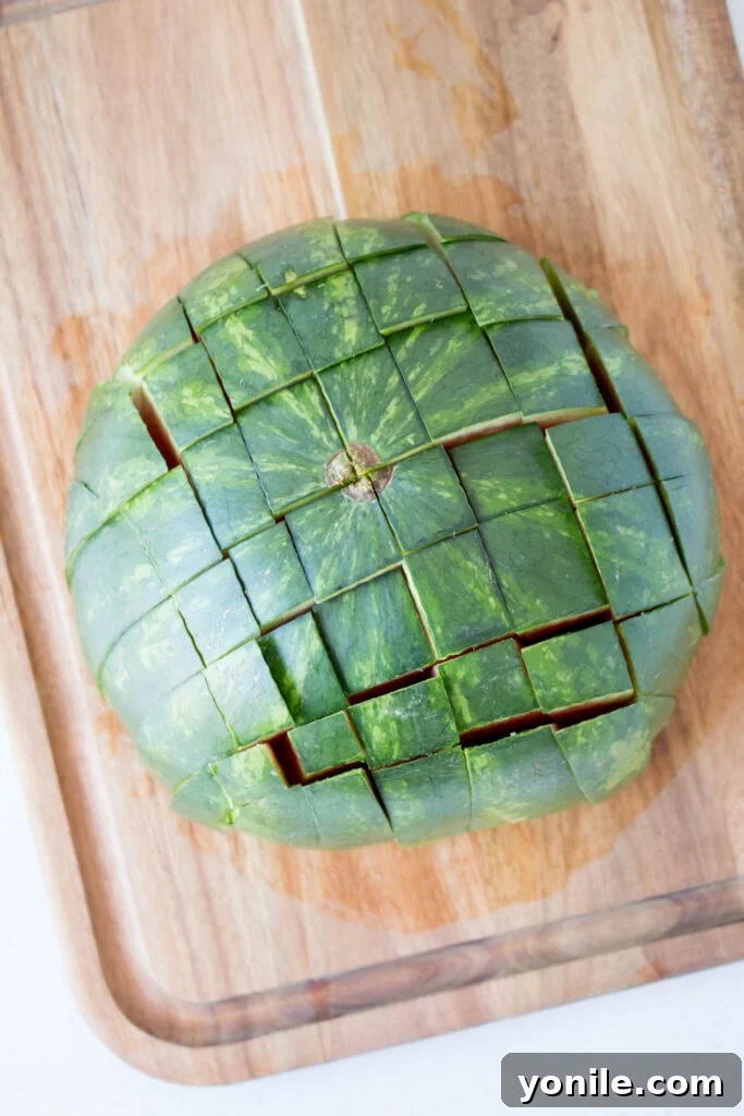 Slice Watermelon Like a Pro 8 A watermelon half scored into a grid pattern, ready to be separated into sticks.