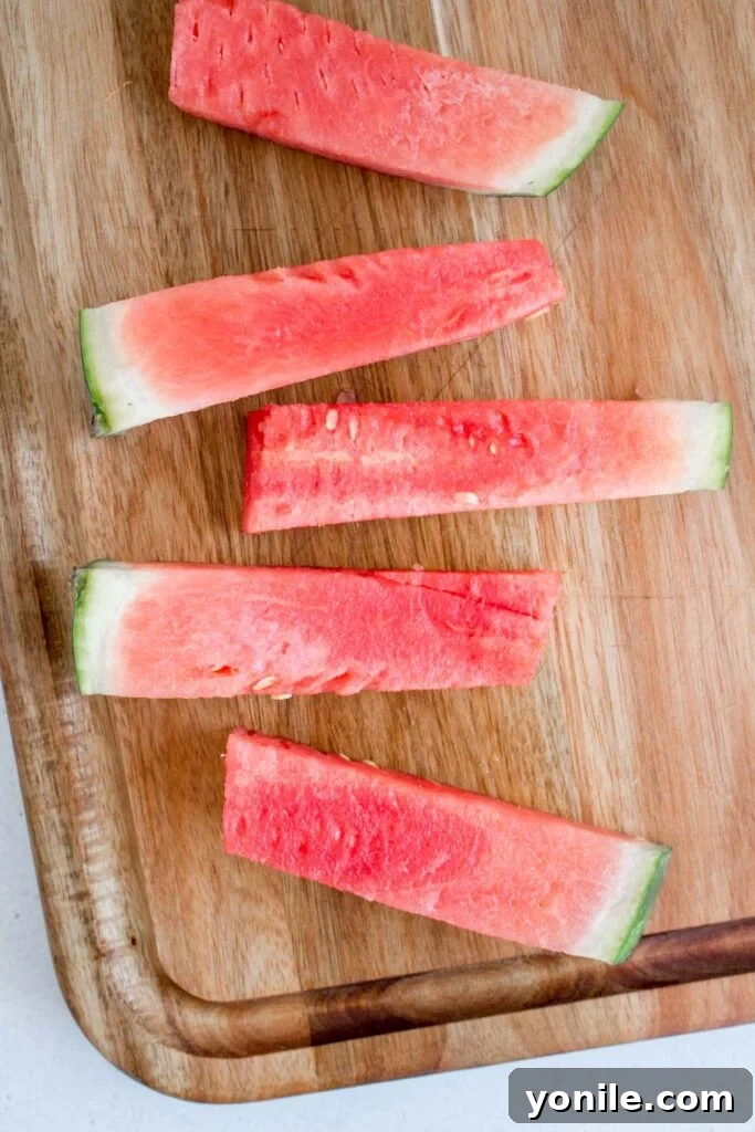 Slice Watermelon Like a Pro 10 A pile of uniform watermelon sticks arranged neatly on a serving dish.