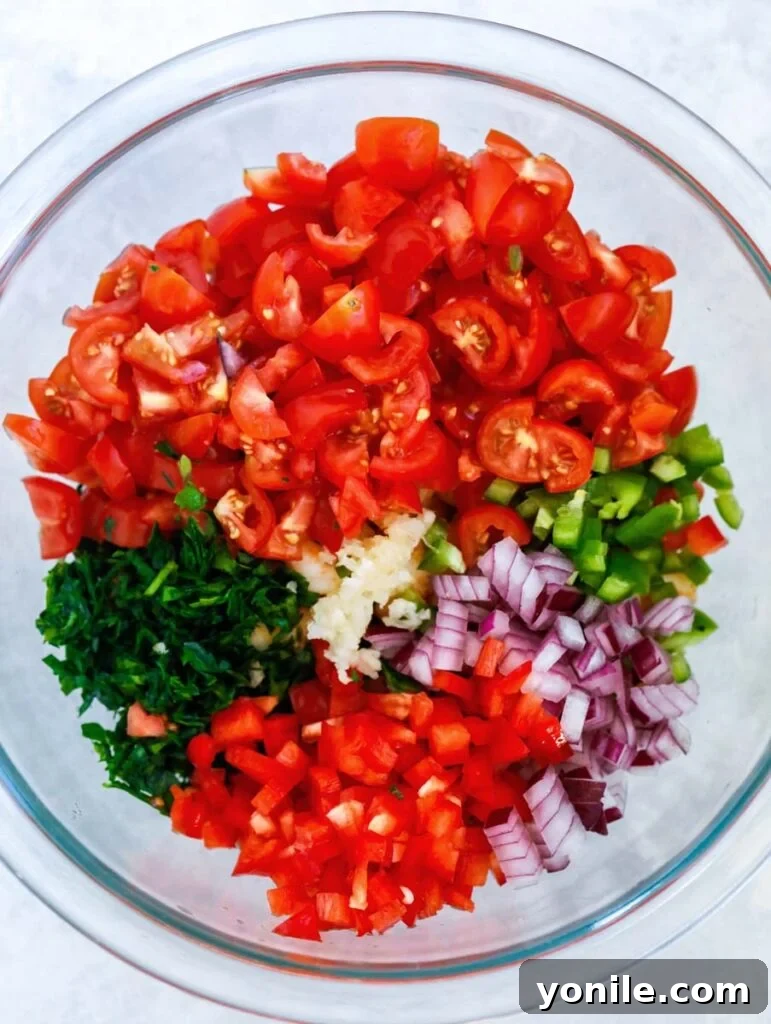 various fresh ingredients for shrimp stuffed avocado in a glass bowl, ready for preparation.