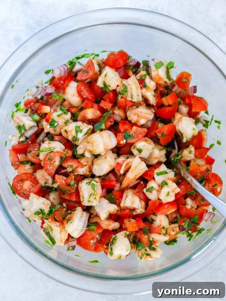 top down shot of mixing the shrimp filling with vegetables and seasonings in a bowl.