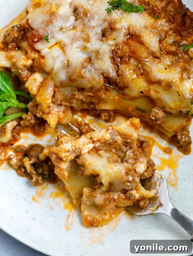 Hearty Beef Lasagna 4 close up of meat lasagna, showcasing the perfectly melted cheese and layered ingredients.
