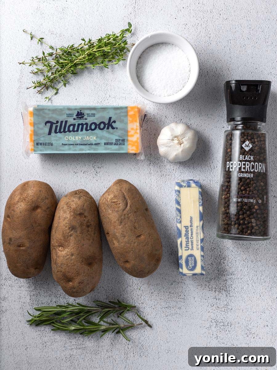 Fresh ingredients laid out: russet potatoes, butter, cheese, and a sprig of fresh herbs.