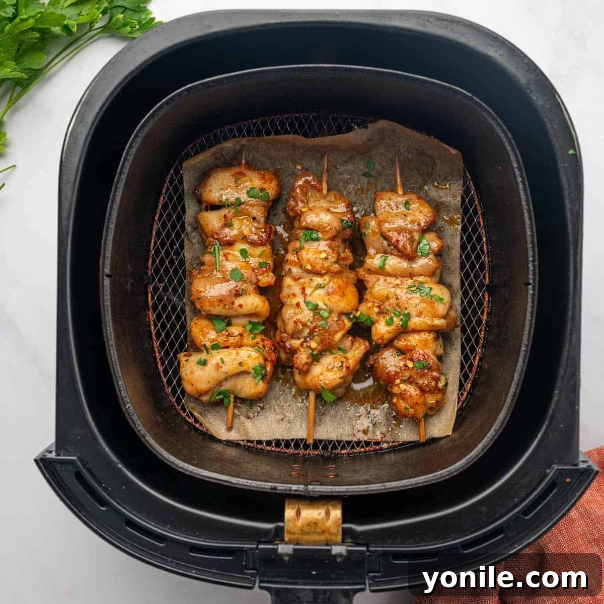 Chicken Skewers Arranged in Air Fryer Basket  with Crispy Edges and Juicy Texture. Brushed with butter sauce.