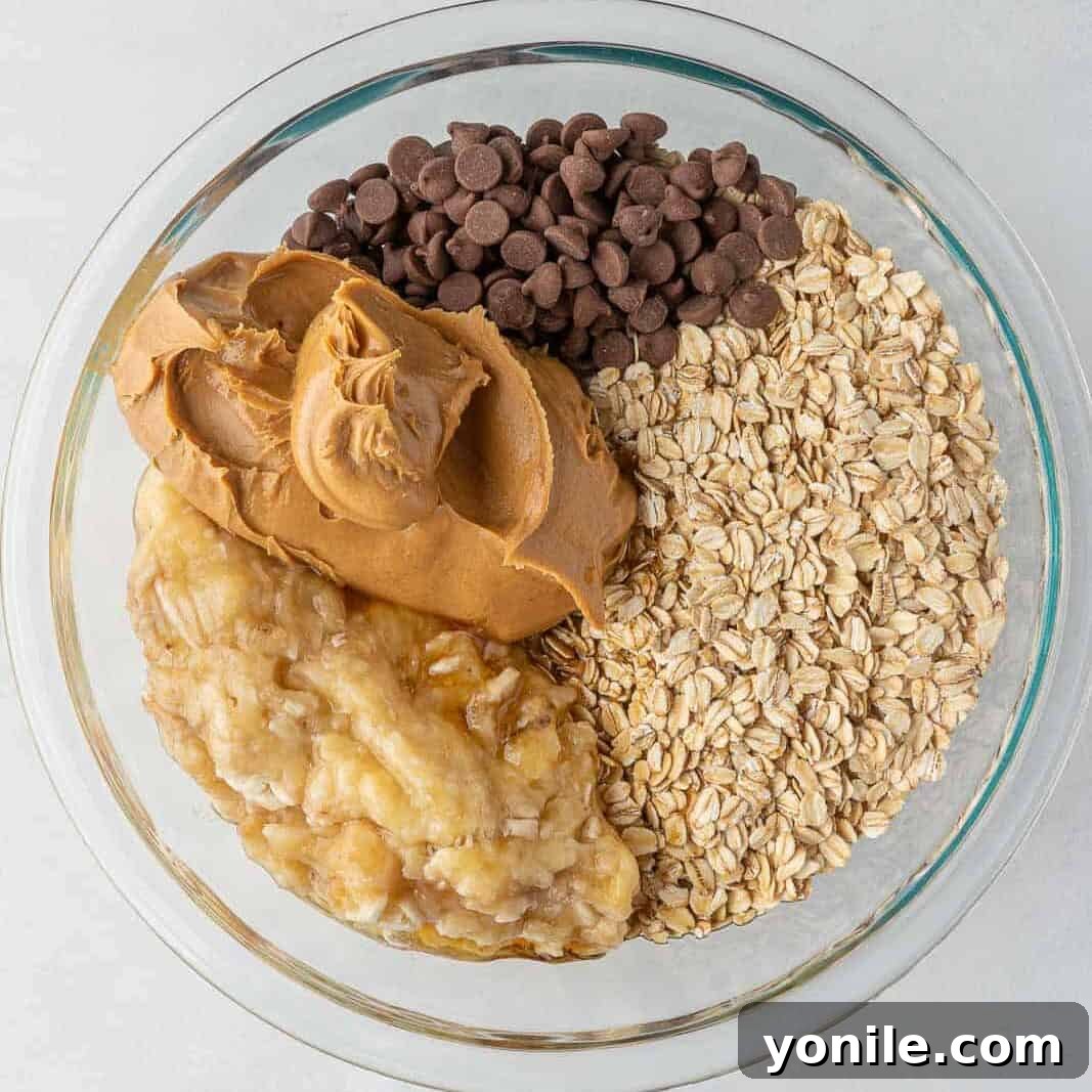 Chewy Chocolate Chip Peanut Butter Oatmeal Bars 4 Oatmeal bar ingredients in a clear baking bowl.